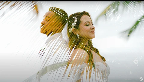 Woman with braided hair and white flowers in profile, with double exposure showing grass and natural landscape.