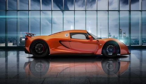 Orange sports car positioned in profile against floor-to-ceiling windows overlooking a city skyline.