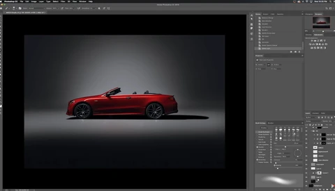 Red convertible sports car photographed in profile against a dark gradient studio background.
