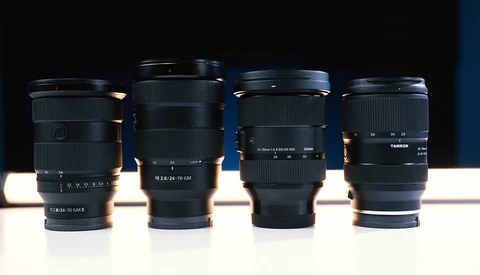 Four camera lenses arranged in a row against a dark background with dramatic side lighting.
