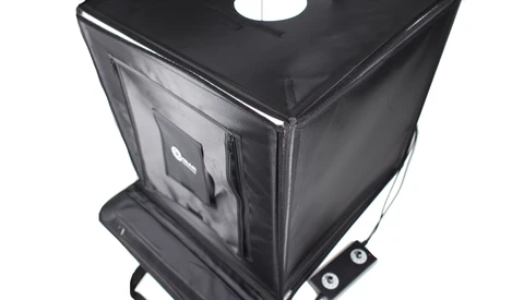 Black fabric photography light tent with translucent panels and carrying case on wheels.