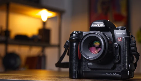 Fujifilm GFX S2 Pro medium format camera on a wooden table with warm studio lighting in the background.