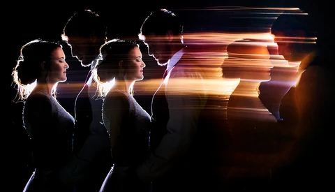 Profile silhouettes of a woman with glowing light trails and motion blur effects against a dark background.