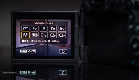 Screenshot of a digital camera's LCD screen displaying manual exposure mode options and shooting settings.