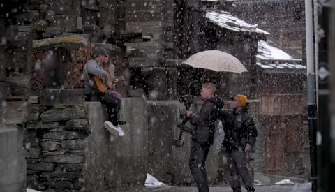 People with umbrellas walking in heavy rain on a wet urban street.