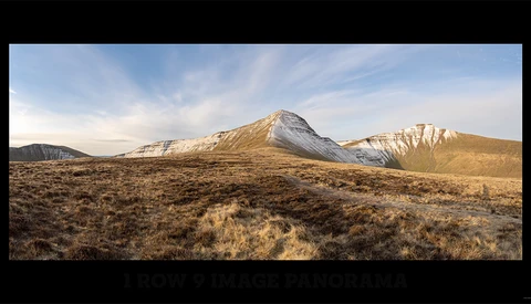 Snow-capped mountain peak rising above arid, sparsely vegetated desert landscape under partly cloudy sky.
