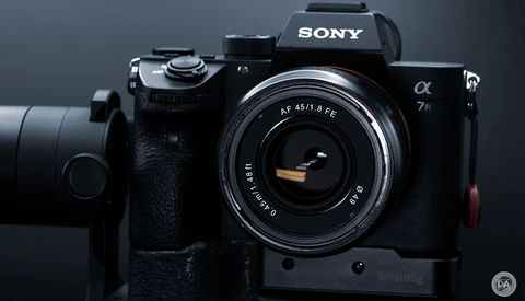 Sony α7 II mirrorless camera with 45mm f/1.8 lens mounted, displayed against a dark gray background.