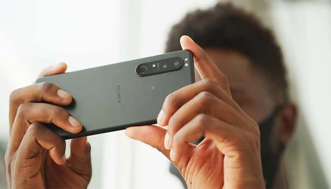 Person holding a Sony smartphone in landscape orientation while photographing, with camera module visible on the back.
