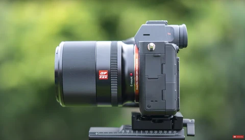 Sony mirrorless camera with telephoto lens mounted on a measurement scale.
