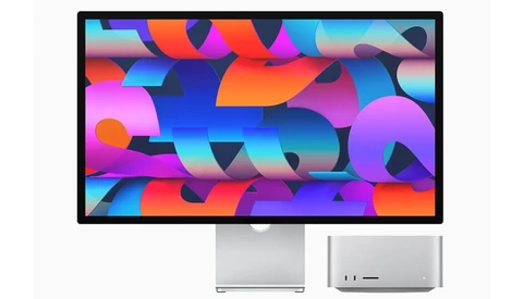 Desktop monitor displaying vibrant abstract wallpaper with colorful geometric shapes and gradients.