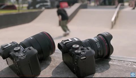 Two DSLR cameras with telephoto lenses positioned on concrete at a skate park with blurred skaters in background.