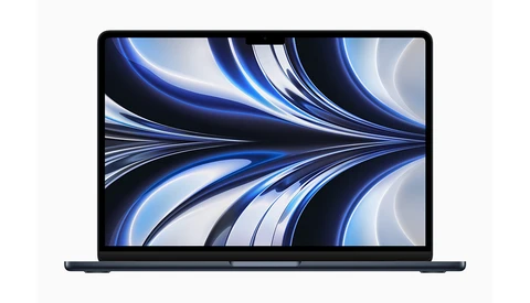 Laptop displaying abstract blue and white flowing wave patterns on its screen.