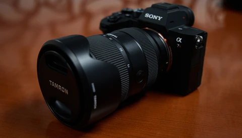 Sony mirrorless camera with Tamron lens mounted on wooden surface.