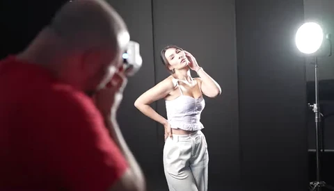 Female model posing during a studio photoshoot with professional lighting setup.