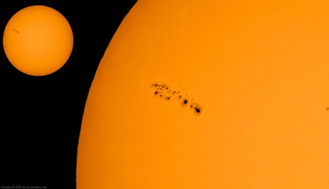 The sun photographed in extreme close-up showing sunspots and surface detail, with a smaller full-disk solar image in the upper left for scale comparison.