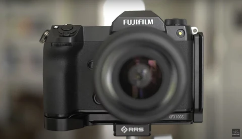 Fujifilm GFX100S medium format camera with RRS L-bracket mounted, shown front-on with blurred background.