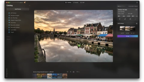European riverside town at golden hour with historic architecture reflected in calm water.