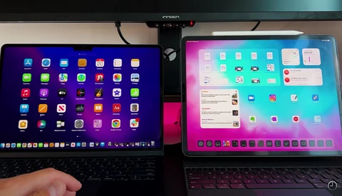Two laptops side by side displaying different operating system home screens with app icons and widgets.