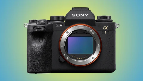 Sony α1 mirrorless camera body with lens mount exposed, shown against gradient blue and yellow background.