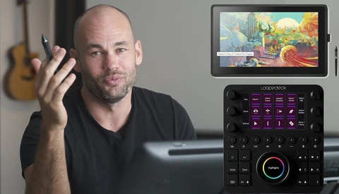 Man demonstrating a digital control panel with a display tablet mounted above showing colorful visual content.