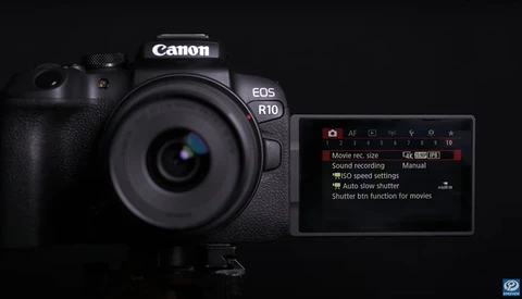 Canon EOS R10 mirrorless camera displayed against a black background with rear LCD screen showing menu options.