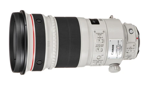 Canon telephoto lens with white barrel, control rings, and focus switches displayed against white background.