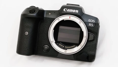 Canon EOS R5 mirrorless camera body with open sensor showing electronic components against white background.