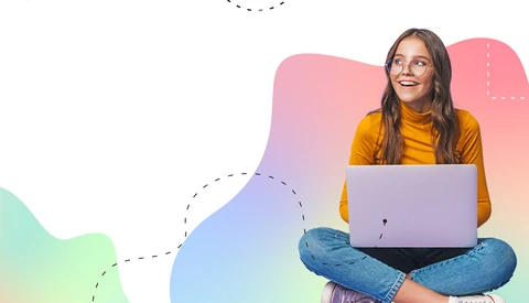 Woman in yellow shirt sitting cross-legged with laptop, smiling against colorful gradient background.