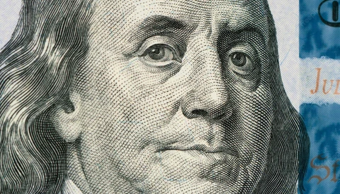 Engraved portrait of a man with long hair, rendered in fine parallel lines and crosshatching on currency.