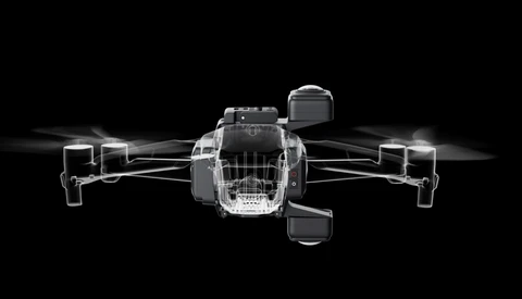 Illustration of a quadcopter drone shown from above with four rotors, rendered in grayscale with transparent shell design against black background.