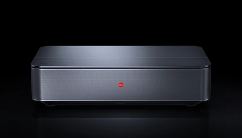 Sleek gray rectangular device with mesh speaker grille and minimalist design against black background.