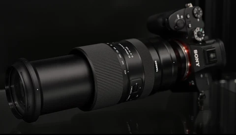 Sony mirrorless camera with telephoto lens mounted, photographed against a dark background.