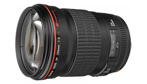 Wide-angle camera lens with red accents and manual focus ring against white background.