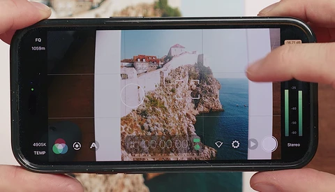 Screenshot of smartphone camera app displaying a coastal cliff landscape with visible exposure and focus controls.
