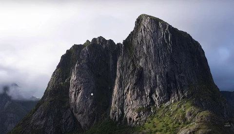 Two dramatic dark rock peaks with vertical columnar formations rising above green alpine slopes under overcast sky.