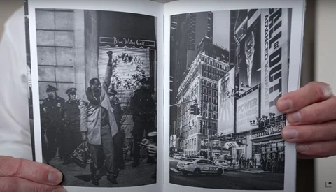 Two open pages of black and white vintage photographs showing urban street scenes with buildings and crowds.