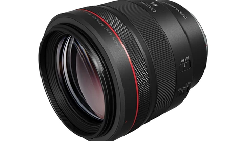 Black telephoto lens with red accent ring and multilayered glass elements visible through the front.