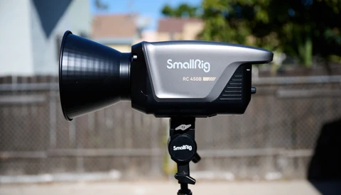 SmallRig RC 450B LED light mounted on a light stand in outdoor daylight with buildings visible in the background.