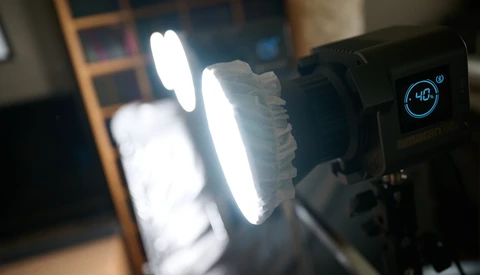 LED panel light with digital display showing color temperature setting during product demonstration.