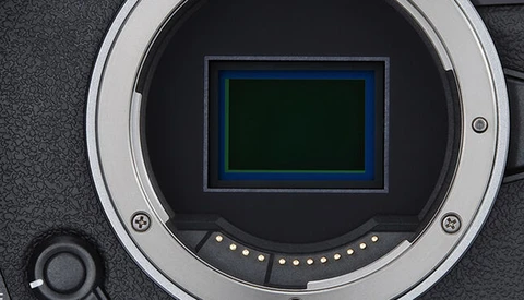 Close-up of a camera's mirror box showing the sensor with blue and dark green protective frames.