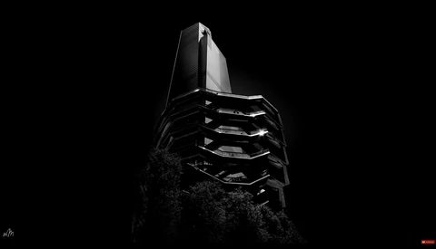 Modern architectural tower shot from below against black sky, featuring geometric horizontal bands of windows.