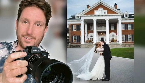 Professional photographer holding Sony mirrorless camera with telephoto lens, smiling at camera.