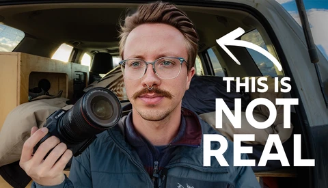 Photographer holding a DSLR camera inside a van, wearing glasses and a puffy jacket.