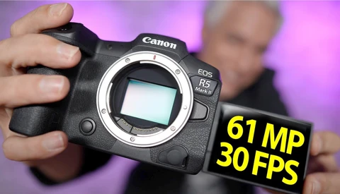 Canon EOS R5 Mark II camera body held in hands against purple background with specs overlay.