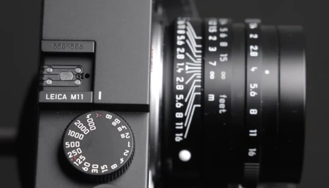 Leica M11 rangefinder camera with lens and shutter speed dial in black and white.
