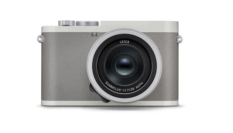 Leica Q2 digital camera with gray leather body and silver top plate, shown from front against white background.