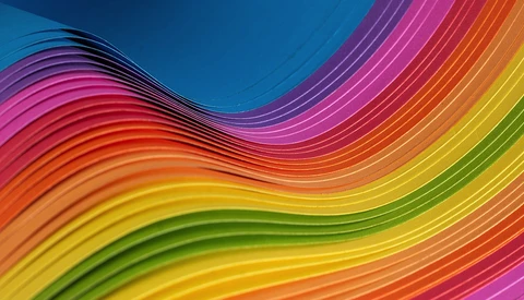 Graphic illustration of undulating waves in rainbow gradient from blue, pink, orange, yellow, and green.