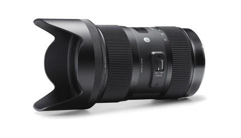 Black telephoto zoom lens with lens hood attached, shown at an angle against a white background.