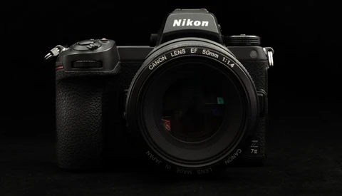 Nikon Z mirrorless camera with Canon 50mm f/1.4 lens mounted against black background.