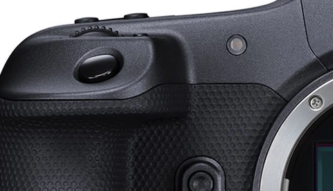 Close-up of a mirrorless camera body showing the grip, textured handhold area, and electronic viewfinder housing.